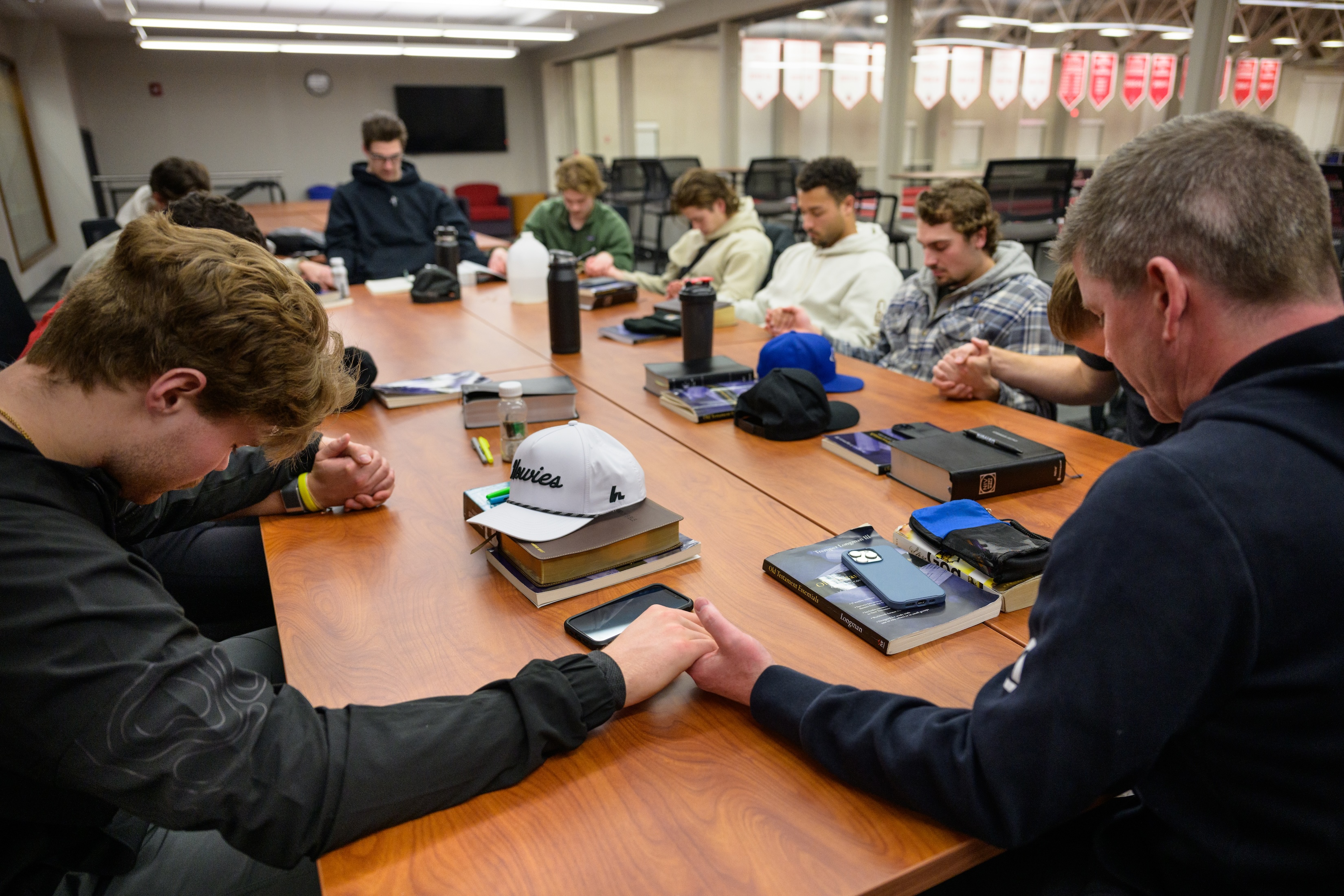 hockey team holding hands while praying