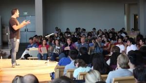 a large group of students listening to a man speak