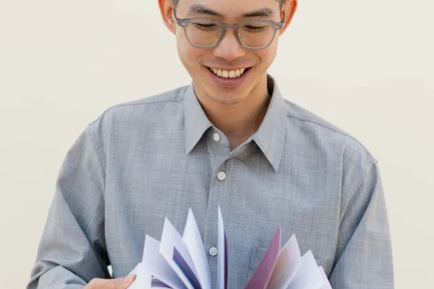 man smiling reading a book