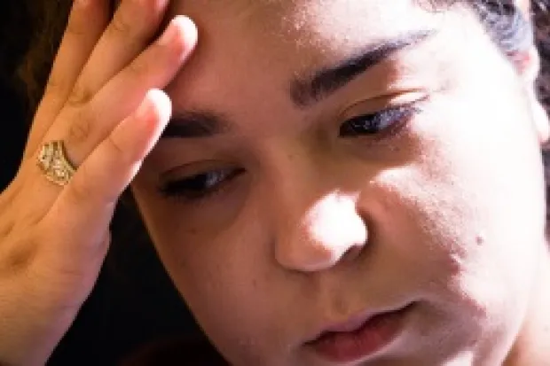 Woman pressing hand to forehead looking discouraged