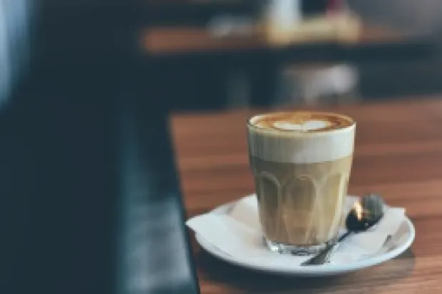 Single latte sitting on the edge of table