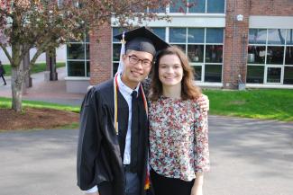 Taylor standing with friend Edwin in his graduation robe