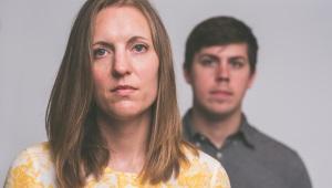 Woman standing in the foreground with man in the background