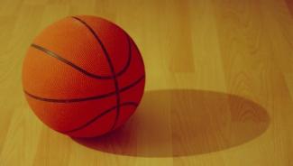 Orange basketball on indoor wooden court