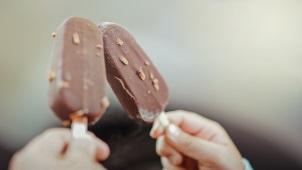 Two people holding up chocolate fudgesicles