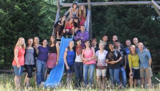 Large group of college students gathered around a playground slide