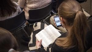 a woman holding an open Bible in her lap at church