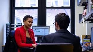 Woman and man wearing business casual clothes talking in office 