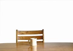 a chair and table with one coffee mug resting on  it