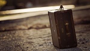 a leather suitcase resting on asphalt