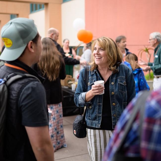 Alumni holding coffee meeting another alumni