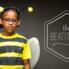 young girl in bee costume, dark gray background