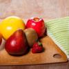 a wooden table with fruits, vegetables, and knife