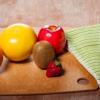 a wooden table with fruits, vegetables, and knife