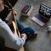 Student sitting on floor playing guitar leading virtual worship