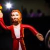 Jesus action figure standing in spotlight with dark background