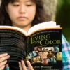 Native female student reading Living in Color book outside