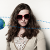 a woman with sunglasses and a small picture of Earth revolving around her head